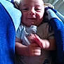 Jasper is registered to the contest to win money with this photo: baby, infant, smiling, clapping, blanket, blue_blanket, cushion, indoor, floor_pattern, onesie, child, happy, face, head, person, comfort, resting, cute, young, portrait