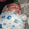 Kairee is registered to the contest to win money with this photo: baby, sleeping, blanket, swaddled, teddy_bear_pattern, blue, white, gray_blanket, face, infant, peaceful, resting, bottle, baby_wipes, soft_texture, indoor, cozy, child, cute, newborn