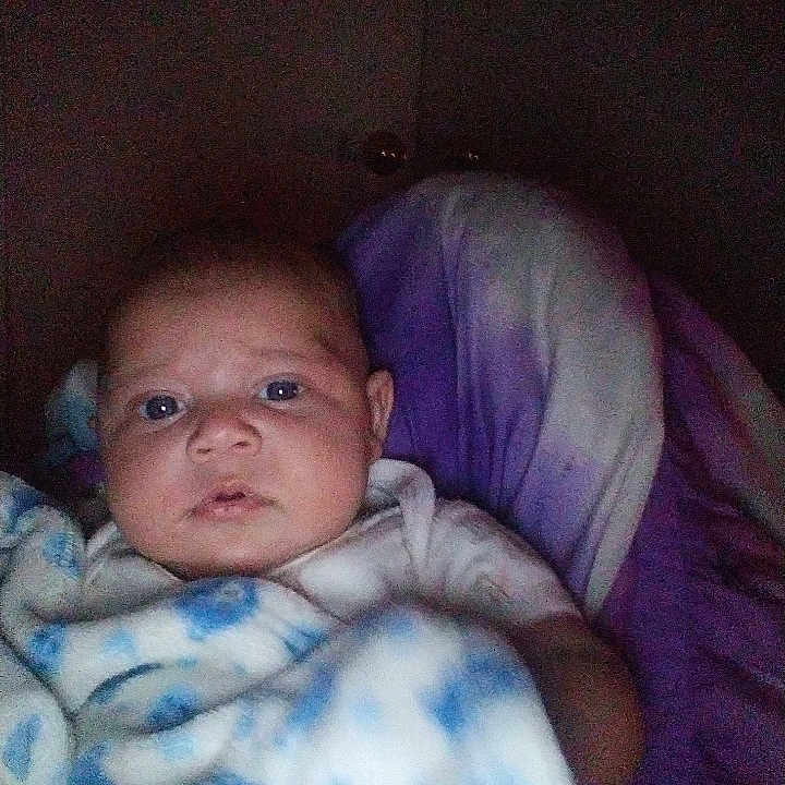 Kairee is registered to the contest to win money with this photo: baby, blanket, blue, purple, pillow, infant, face, person, bedroom, cozy, soft, wrapped, indoors, curious, child, newborn, portrait, sleepy, young, resting