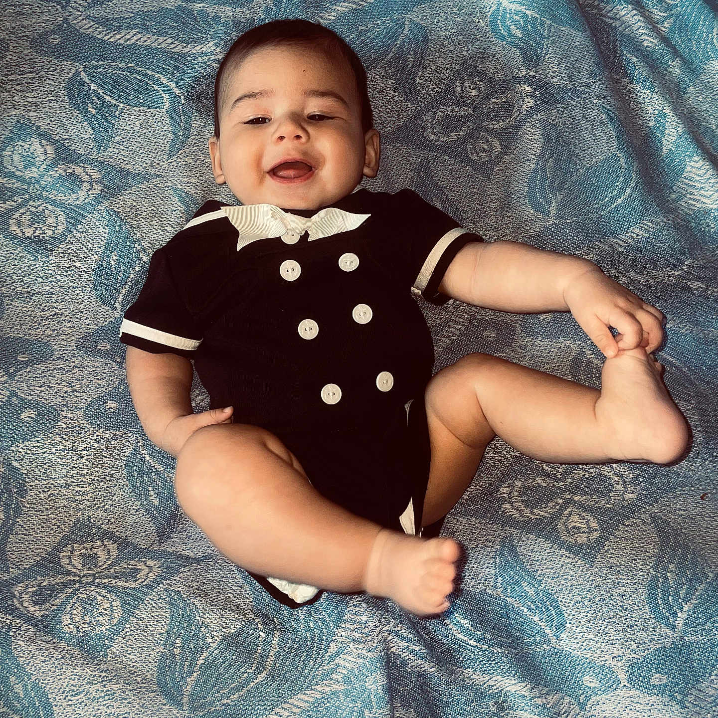 Luis joined the competition — help win amazing prizes! baby, babylaughing, bodypart, clothing, dress, face, finger, furniture, hand, happy, head, laughing, newborn, pants, person, photography, portrait, sitting, smile, t_shirt