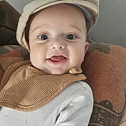 Viktor a rejoint le concours — aidez-le/la à gagner de superbes lots ! arm, baby, bib, cap, child, closeup, clothing, cute, expression, eyes, face, happy, headwear, indoor, infant, person, portrait, skin, smiling, tattoo