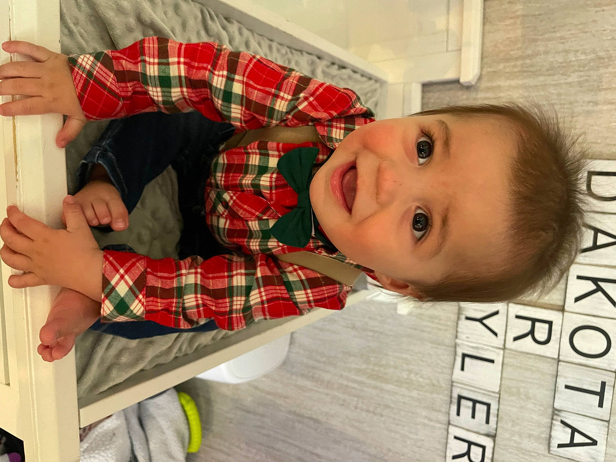 Ryan Jr is registered to the contest to win money with this photo: baby, child, design, eyelash, flooring, font, happy, pattern, person, photo_caption, plaid, room, smile, sock, tartan, toddler, tree, wood