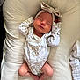 newborn, baby, sleeping, headband, onesie, infant, cute, cozy, cushion, blanket, soft, peaceful, resting, indoors, child, portrait, clothing, human, lying_down, adorable
