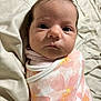 Parker is registered to the contest to win money with this photo: baby, infant, face, swaddle, blanket, pink, floral, newborn, lying_down, portrait, child, cute, soft, fabric, skin, closeup, eyes, head, sleepwear, indoors