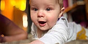 Albie-James joined the competition — help win amazing prizes! baby, infant, face, blue_eyes, hand, white_clothing, crawling, indoor, soft_light, blurred_background, curious, child, person, closeup, skin, young, cute, expression, portrait, warm_colors