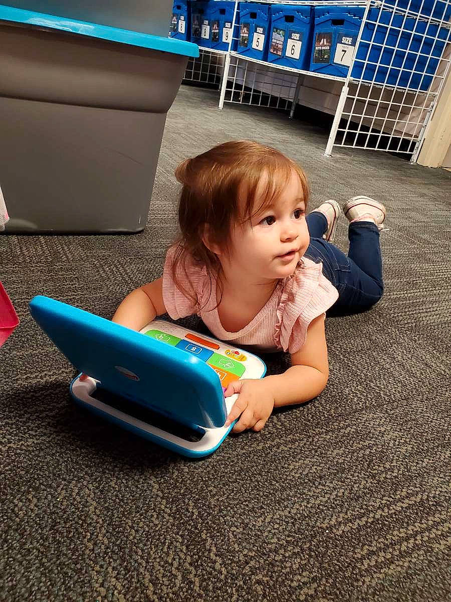 Kya joined the competition — help win amazing prizes! baby, child, electronic_device, floor, flooring, fun, gadget, learning, leg, leisure, person, play, reading, sitting, technology, toddler, vacation