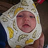 Ezekiel joined the competition — help win amazing prizes! baby, infant, face, bib, clothing, yellow, pattern, cute, sleepy, hand, person, indoor, soft, skin, closeup, portrait, babywear, fabric, coca_cola, drink