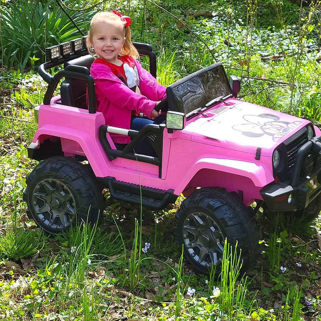 Joplyn joined the competition — help win amazing prizes! automotive_design, automotive_exterior, automotive_tire, automotive_wheel_system, bumper, car, fender, grass, joy, landscape, magenta, motor_vehicle, people_in_nature, person, plant, smile, tire, toddler, tread, tree