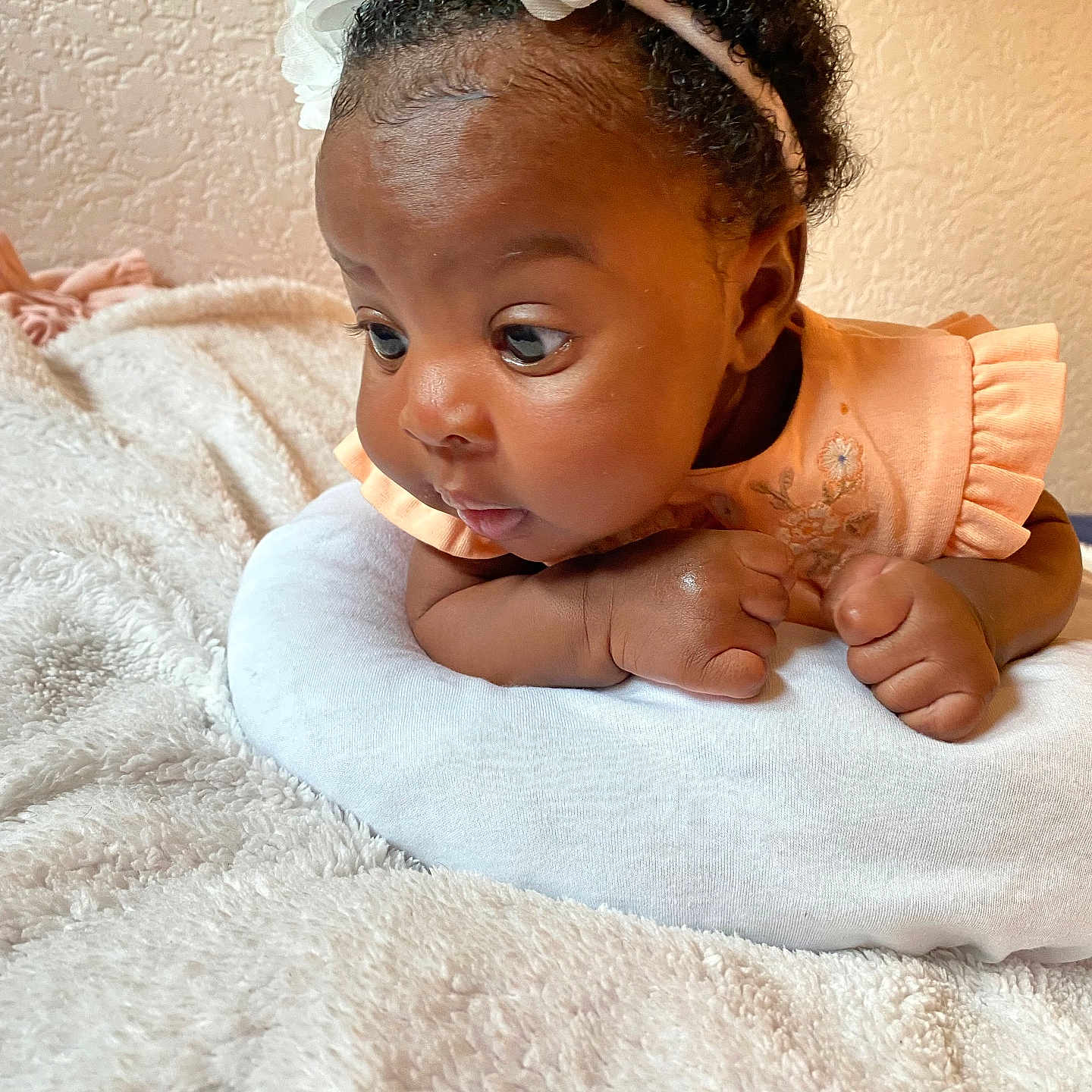 K.ferraz a rejoint le concours — aidez-le/la à gagner de superbes lots ! baby, blanket, child, closeup, curious, cute, face, flower, girl, hands, headband, indoors, infant, lying_down, peach_dress, pillow, portrait, resting, skin, soft_texture