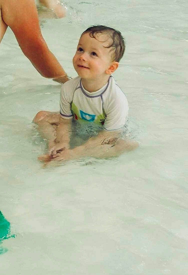 Alessandro participe au concours pour gagner de l'argent avec cette photo : arm, baby, barefoot, bathing, body_of_water, child, face, facial_expression, fun, hair, hand, happy, head, joy, leg, leisure, people_on_beach, person, shorts, smile