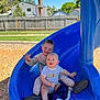 Avery joined the competition — help win amazing prizes! child, baby, slide, playground, outdoor, smiling, blue_slide, blanket, grass, fence, house, sunny, happy, toddler, casual_clothing, footwear, daytime, person, play, fun