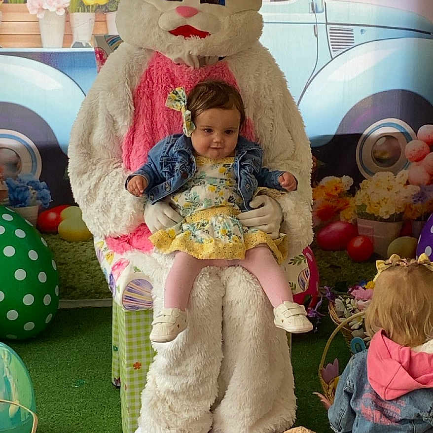 Laylani joined the competition — help win amazing prizes! toddler, child, bunny_costume, plush_toy, easter, decorations, flowers, green_grass, denim_jacket, dress, toy, indoor, costumed_character, kids, play, event, colorful, background, cute, spring
