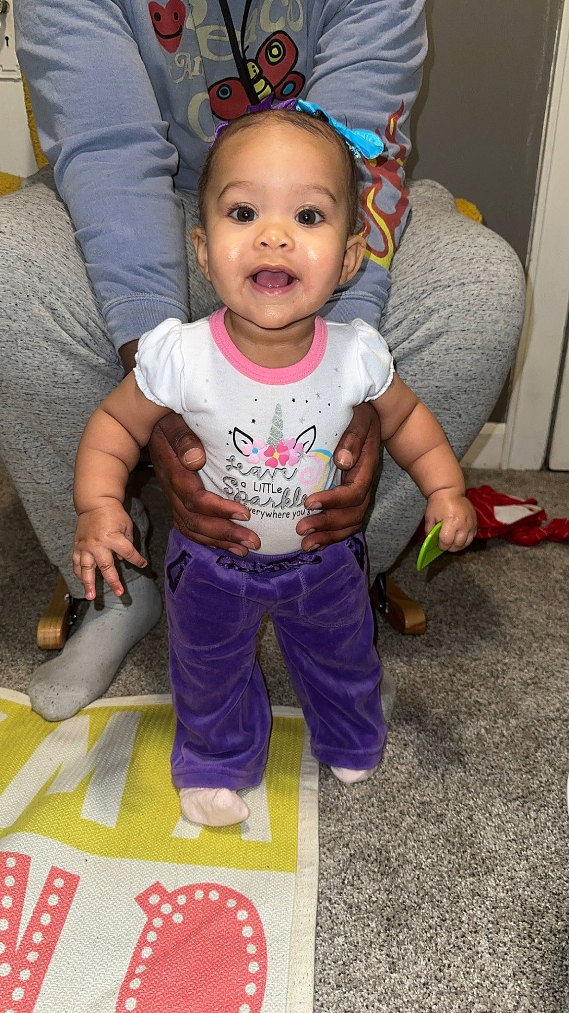 Layana is registered to the contest to win money with this photo: baby, baby_toddler_clothing, cheek, child, costume_hat, eye, face, flooring, fun, hairstyle, happy, people, person, pink, purple, sitting, skin, sleeve, smile, t_shirt