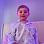Jaxson is registered to the contest to win money with this photo: child, toddler, pajamas, blue, checkered, teddy_bear, smiling, portrait, indoor, bedroom, soft_lighting, cozy, cute, person, face, young_child, happy, clothing, bed, purple_light