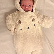 Maggie-Olwen is registered to the contest to win money with this photo: baby, infant, onesie, hood, bear_ears, cute, cozy, soft_texture, lying_down, blanket, portrait, child, smiling, face, clothing, warm, indoor, newborn, adorable, babywear