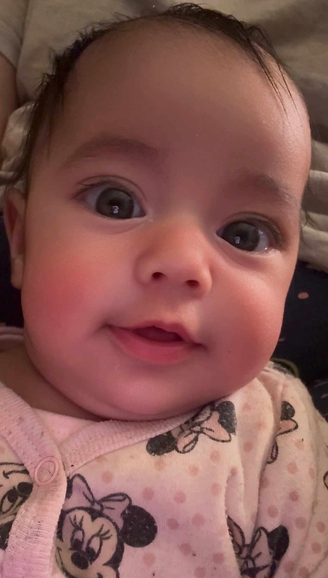 Jouri joined the competition — help win amazing prizes! baby, close_up, face, infant, child, pink_clothing, minnie_mouse, cartoon_print, cute, adorable, expression, portrait, young_child, eyelashes, soft_lighting, indoor, sleepwear, smile, chubby_cheeks, head