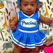 Harmoni is registered to the contest to win money with this photo: baby, blue_outfit, cheerleader_dress, headband, pom_poms, baby_booties, jungle_pillow, animal_print, hello_kitty_blanket, indoor, child, cute, infant, smiling, portrait, colorful, soft_toys, decor, sitting, playful