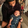 Harmoni is registered to the contest to win money with this photo: baby, child, woman, holding, denim_dress, headband, chair, holiday_lights, christmas_decor, indoor, portrait, smile, happy, family, person, seated, wood_floor, jewelry, black_clothing, warm_lighting