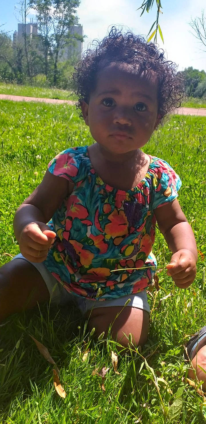Kaïna participe au concours pour gagner de l'argent avec cette photo : adaptation, botany, eye, facial_expression, finger, fun, grass, green, hair, hairstyle, happy, head, leaf, nose, people_in_nature, person, plant, skin, sunlight, toddler