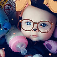 Emerald is registered to the contest to win money with this photo: baby, infant, face, glasses_filter, dog_ears_filter, bottle, toy, plush_toy, blue_eyes, hand, blanket, closeup, cute, digital_filter, heart_shapes, child, indoors, portrait, soft_lighting, baby_clothing