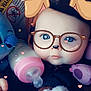 baby, infant, face, glasses_filter, dog_ears_filter, bottle, toy, plush_toy, blue_eyes, hand, blanket, closeup, cute, digital_filter, heart_shapes, child, indoors, portrait, soft_lighting, baby_clothing