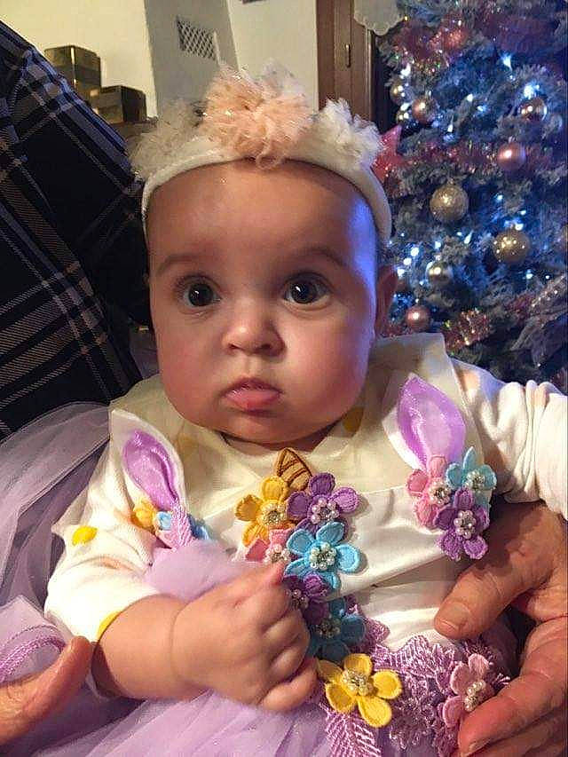 Iris participe au concours pour gagner de l'argent avec cette photo : baby, baby_toddler_clothing, cheek, christmas_tree, dress, event, eyelash, fun, hair, hairstyle, happy, head, iris, lip, person, pink, plant, purple, skin, surprise