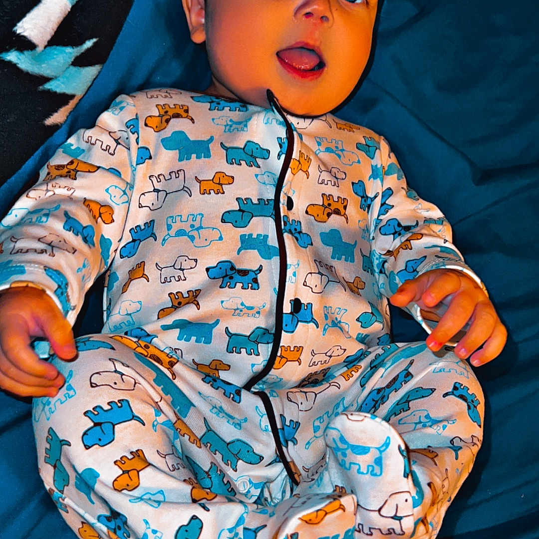 Steven joined the competition — help win amazing prizes! baby, bed, blanket, blue_sheet, child, cozy, cute, dog_pattern, fabric, feet, hands, infant, lying_down, nursery, onesie, pajamas, portrait, sleepwear, smiling, tongue_out