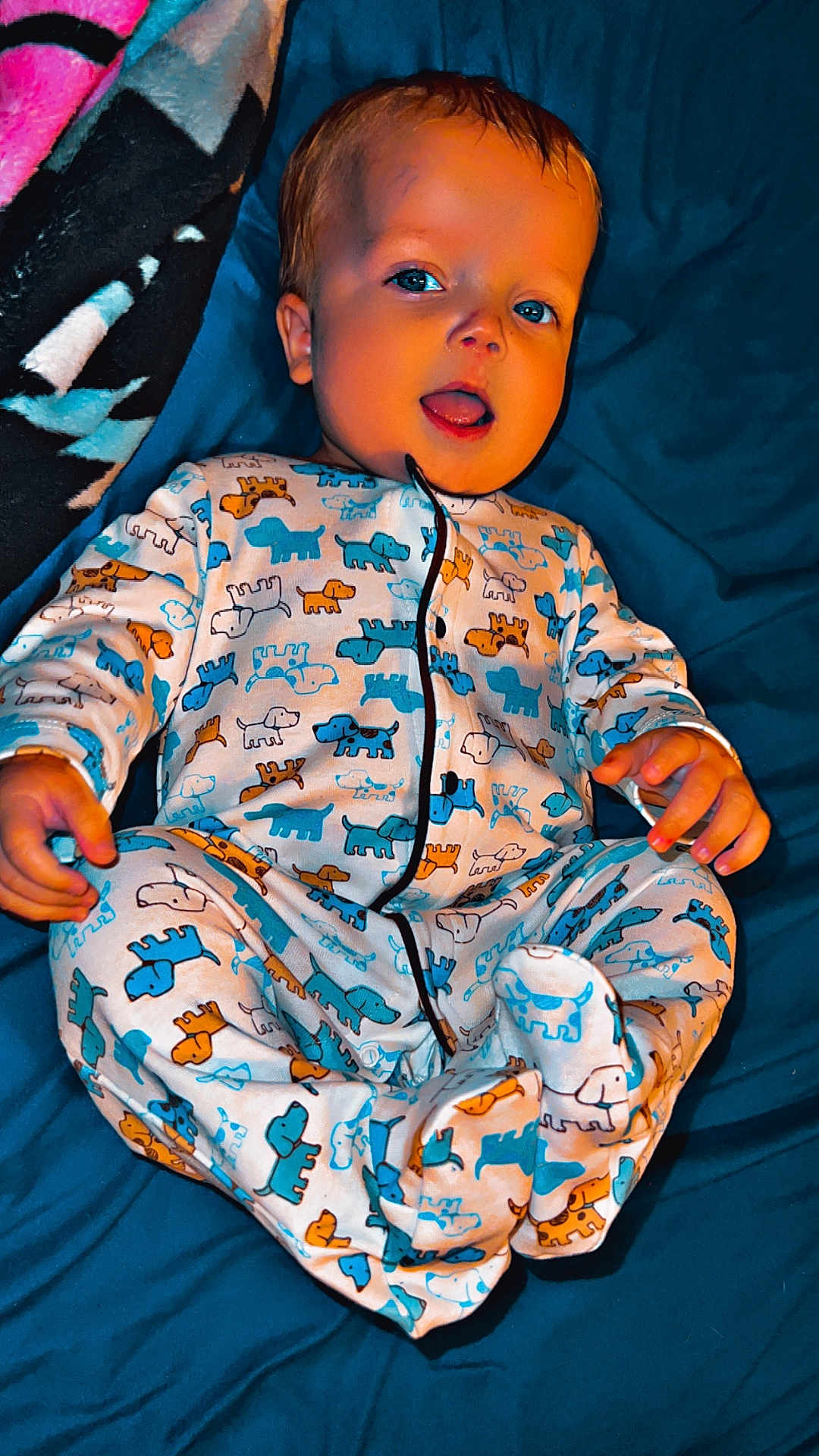 Steven joined the competition — help win amazing prizes! baby, infant, child, onesie, pajamas, dog_pattern, blanket, bed, blue_sheet, smiling, tongue_out, lying_down, hands, feet, portrait, cute, cozy, sleepwear, nursery, fabric