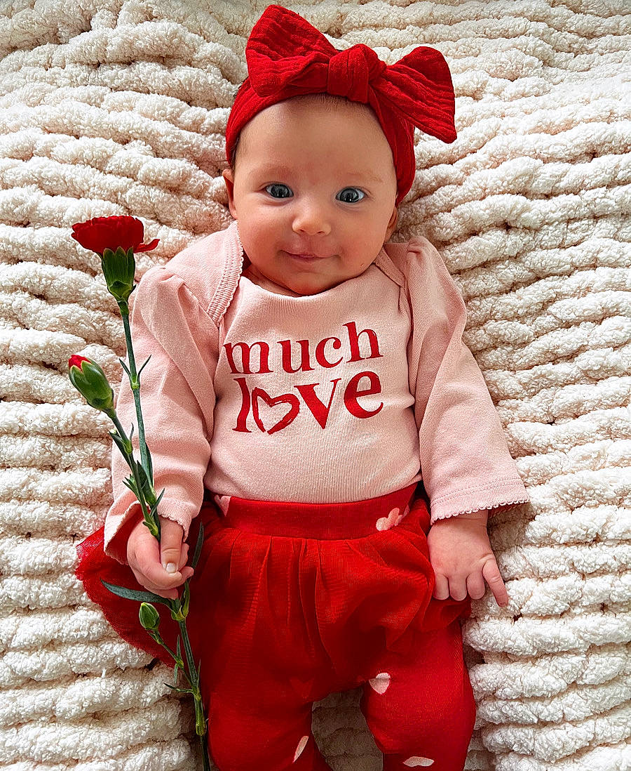 Leighton is registered to the contest to win money with this photo: baby, baby_toddler_clothing, cap, child, clothing, costume_hat, font, happy, head, headgear, pattern, person, pink, product, red, sleeve, t_shirt, textile, toddler, white