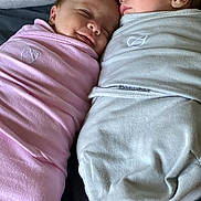 Leland And Adaline joined the competition — help win amazing prizes! baby, infant, newborn, swaddled, sleeping, bed, blanket, pink, gray, cute, peaceful, child, face, head, resting, person, indoor, soft, warm, together