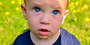 Sebastian is registered to the contest to win money with this photo: baby, blue_eyes, child, curious, cute, expression, face, flowers, garden, grass, nature, navy_shirt, outdoor, person, portrait, sitting, summer, sunlight, toddler, yellow_flowers
