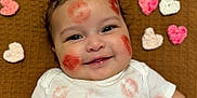 Owen joined the competition — help win amazing prizes! adorable, baby, brown_blanket, cheeks, child, close_up, crocheted_hearts, cute, eyes, face, hair, happy, infant, lipstick_marks, lying_down, playful, portrait, skin, smile, white_shirt