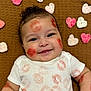Owen joined the competition — help win amazing prizes! baby, infant, smile, face, lipstick_marks, white_shirt, crocheted_hearts, brown_blanket, cute, happy, close_up, portrait, child, cheeks, eyes, hair, skin, lying_down, adorable, playful
