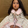 child, girl, portrait, long_hair, coat, pink, dress, hands, sitting, cute, expression, face, fur_collar, fur_cuffs, indoor, brown_background, fashion, young, person, studio