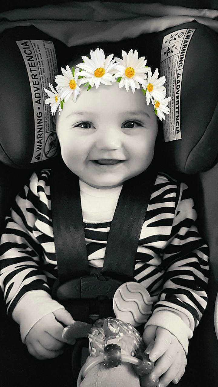 Aiyana is registered to the contest to win money with this photo: arm, baby, black, clothing, dress, eye, face, flash_photography, flower, hand, happy, head, headwear, iris, joy, person, petal, photograph, plant, product