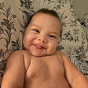 Dariel joined the competition — help win amazing prizes! baby, infant, child, portrait, smiling, tongue_out, face, eyes, bare_shoulders, skin, lying_down, bed, pillow, floral_pattern, home, indoor, close_up, happy, adorable, photography