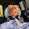 Vaeda is registered to the contest to win money with this photo: baby, infant, car_seat, headband, bow, blanket, child, sunlight, portrait, face, sitting, clothing, safety_harness, seat, outdoor, parking_lot, cute, expression, person, newborn