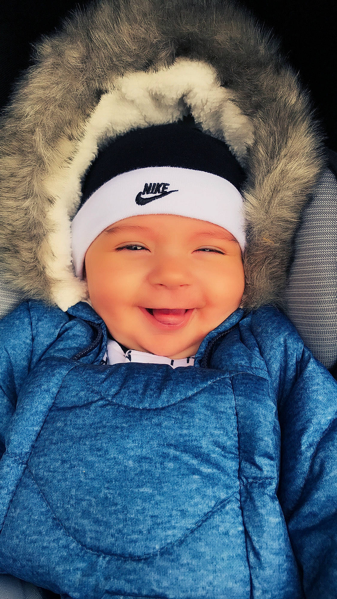 Maximilian is registered to the contest to win money with this photo: baby, beanie, beauty, blue, cap, cheek, child, cool, eye, face, facial_expression, forehead, fun, fur, happy, head, headgear, headwear, joy, person