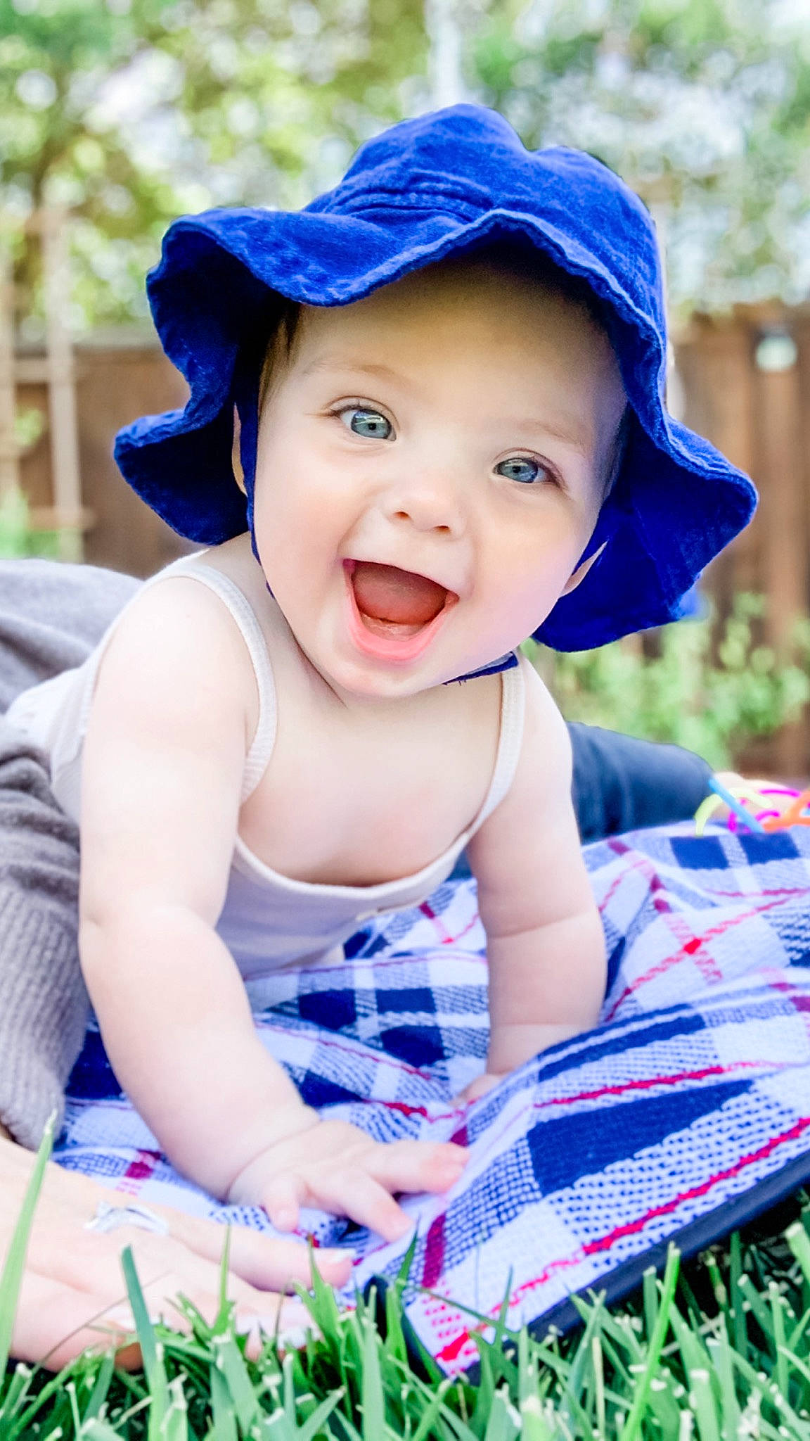 Collins is registered to the contest to win money with this photo: baby, baby_toddler_clothing, blue, cap, child, face, facial_expression, grass, green, happy, hat, headgear, headwear, leisure, people_in_nature, person, photograph, smile, summer, sun_hat
