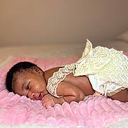 Sky is registered to the contest to win money with this photo: baby, infant, newborn, lying_down, pink_blanket, lace_clothing, soft_texture, closeup, sleepy, cute, portrait, skin, face, hand, foot, bed, cozy, resting, indoors, child