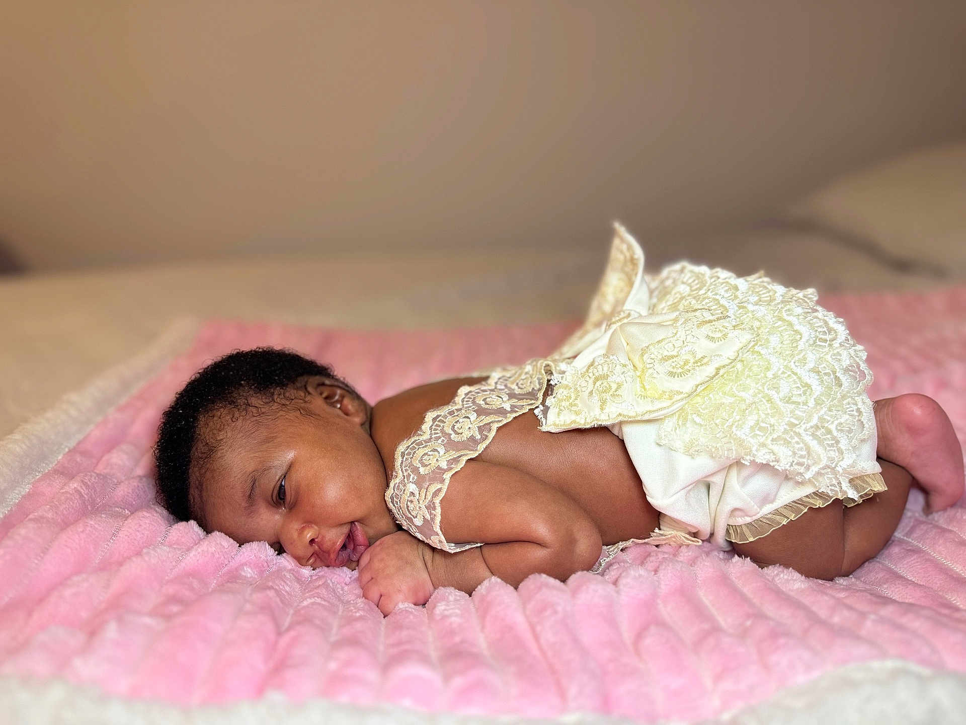 Sky is registered to the contest to win money with this photo: baby, infant, newborn, lying_down, pink_blanket, lace_clothing, soft_texture, closeup, sleepy, cute, portrait, skin, face, hand, foot, bed, cozy, resting, indoors, child