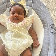 Christine joined the competition — help win amazing prizes! baby, baby_seat, carpet, child, clothing, comfort, cushion, cute, face, hand, headband, indoor, infant, legs, person, portrait, skin, smile, yellow_dress, young