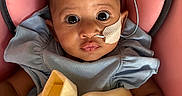 Naavya is registered to the contest to win money with this photo: baby, infant, child, face, eyes, feeding_tube, blanket, blue_clothing, pink_cushion, hospital, medical, healthcare, resting, portrait, closeup, skin, hands, young_child, indoors, cute
