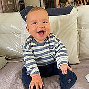 Bastiann participe au concours pour gagner de l'argent avec cette photo : baby, child, clothing, couch, cozy, cushion, cute, furniture, happy, home, indoor, infant, person, playful, portrait, sitting, smiling, sock, striped_shirt, young_child