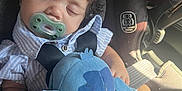 Josiah is registered to the contest to win money with this photo: baby, sleeping, pacifier, car_seat, stuffed_toy, blue, child, infant, seatbelt, clothing, peaceful, indoors, cute, young, toy, comfort, relaxation, portrait, closeup, soft_light