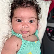 Emilly joined the competition — help win amazing prizes! baby, child, curly_hair, smile, mint_green, lemon_print, pillow, quilted, face, eyes, infant, cute, skin, clothing, portrait, lying_down, indoors, head, person, happy