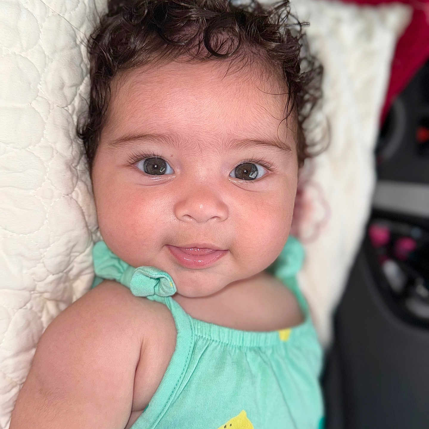 Emilly joined the competition — help win amazing prizes! baby, child, clothing, curly_hair, cute, eyes, face, happy, head, indoors, infant, lemon_print, lying_down, mint_green, person, pillow, portrait, quilted, skin, smile