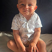Lyvio a rejoint le concours — aidez-le/la à gagner de superbes lots ! toddler, child, baby, sitting, shirt, shorts, indoor, blanket, face, hands, feet, natural_light, curious, portrait, young_child, furniture, home, cute, expression, casual_clothing