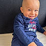 toddler, child, smiling, blue_clothing, couch, indoor, happy, portrait, person, sitting, baby, face, human, casual, cute, playful, young_child, long_sleeve, pants, home