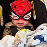 baby, black, blanket, car_seat, child, cozy, cute, eyes, face, indoor, infant, portrait, red, seatbelt, sitting, smiling, spiderman, superhero_mask, textile, vehicle